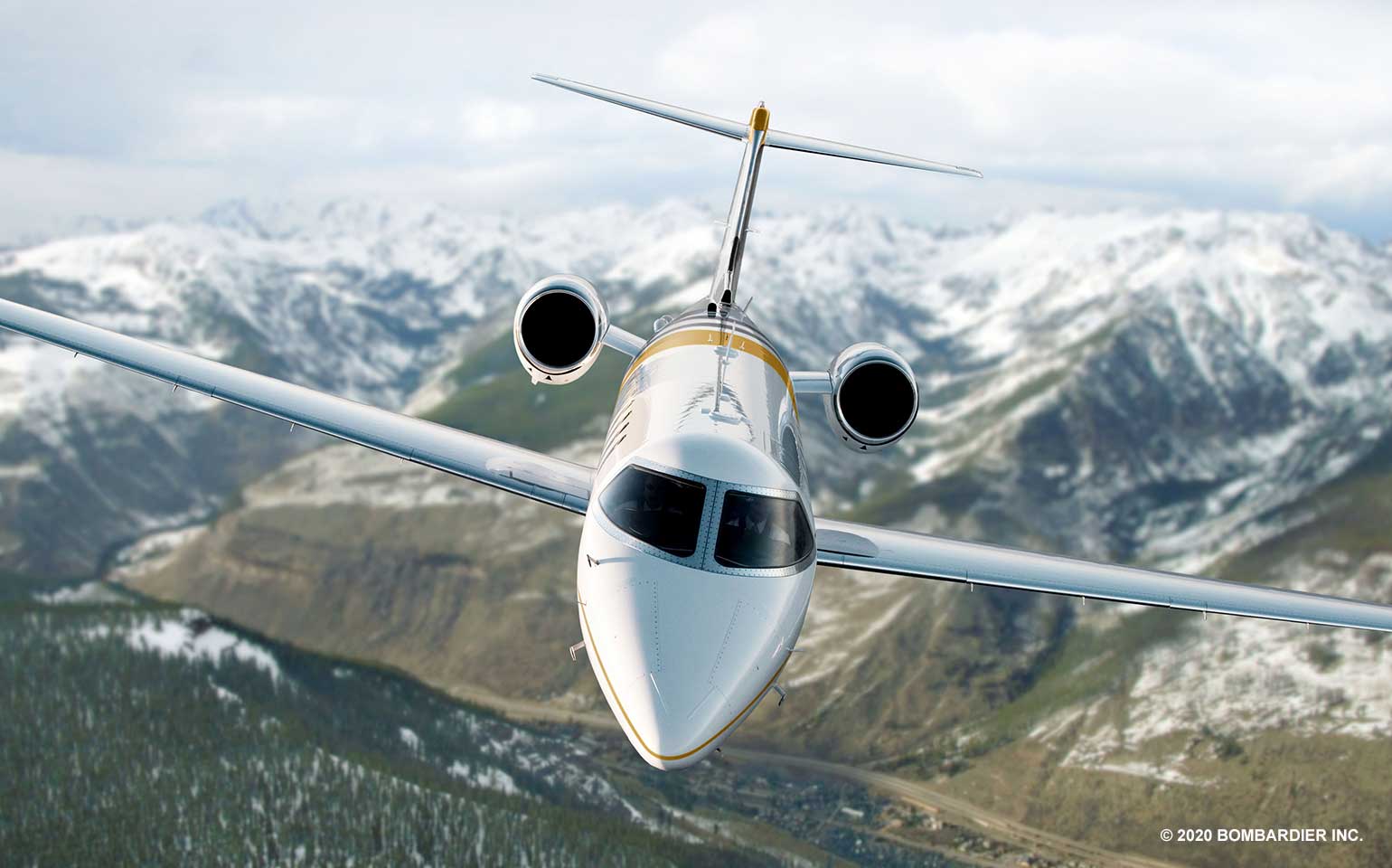 Learjet 75 private jet charter flying over snow covered valley
