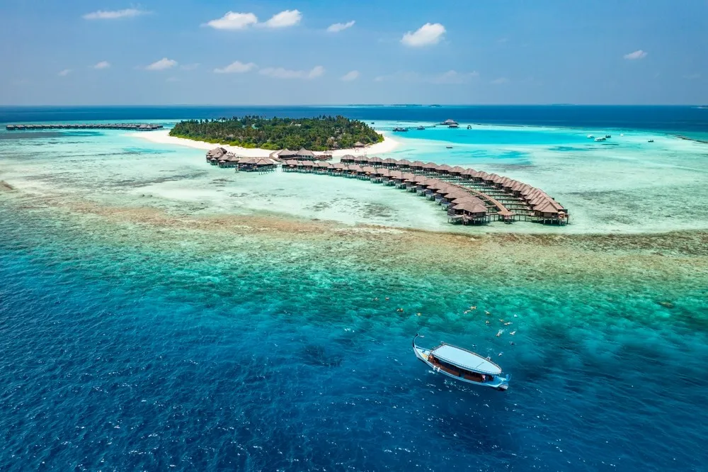 Luxury island landscape in Maldives. Sail boat blue sea water horizon reef water villas.